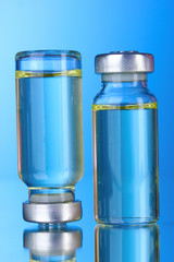 Two medical ampoules on blue background