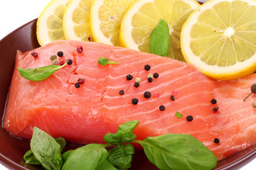 Red fish on the plate with pepper and green leaves