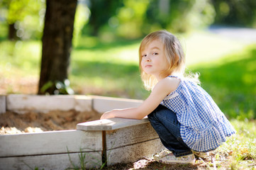 Adorable little girl playing in a sandbox