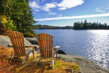 Foto op Plexiglas Adirondack-stoelen aan de oever van het meer © Elenathewise