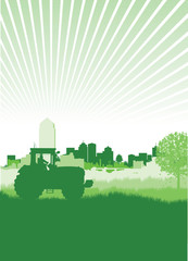 tractor in a field in front of a cityscape