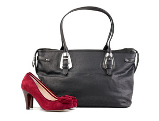 Pair of red female shoes and black handbag over white