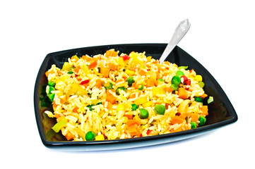 Black square plate with salad from rice and vegetables