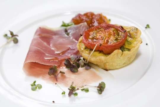 Breakfast quiche, topped with grilled tomato and parma ham.