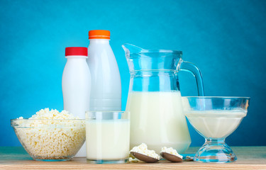Dairy products on wooden table on blue background