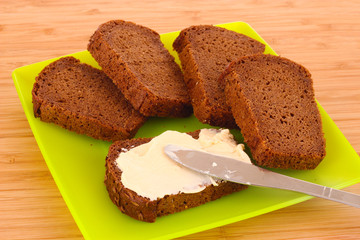 knife and a bread with butter on the plate