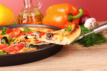 pizza and vegetables on wooden background