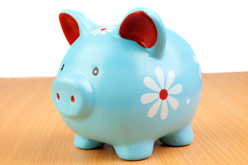Blue piggy-bank on a wooden table