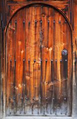 old wooden textured door with metal handle and nails