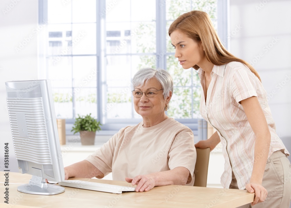 Wall mural senior mother and daughter using computer