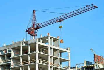 Crane and building construction site against blue sky