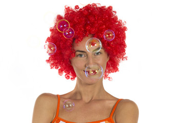 Beautiful woman in an orange wig with soap bubbles