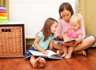 mother with her daughters reading a book