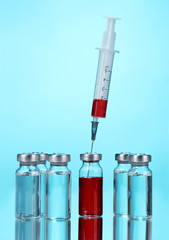 Obraz na płótnie Canvas medical ampoules and syringe on blue background