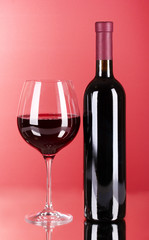 Wine bottle and glass on red background