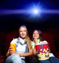 Naklejka premium Two young girls in cinema