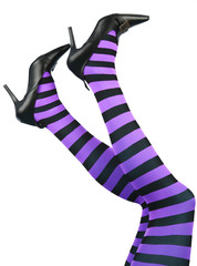 Sexy witch's legs in striped stockings and high heels.
