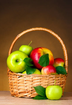 Basket of organic apples on brown background