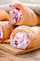 Cream-filled pastry roll on the wood board