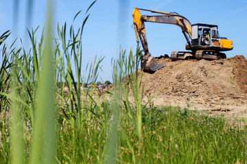 Heavy excavator on stack of earth