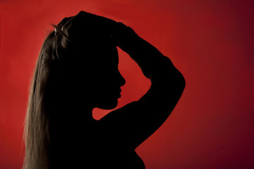 profilo nero di una giovane donna bionda su sfondo rosso
