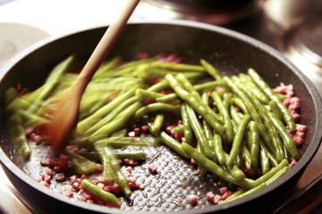Bratpfanne mit Kochlöffel und Bohnen