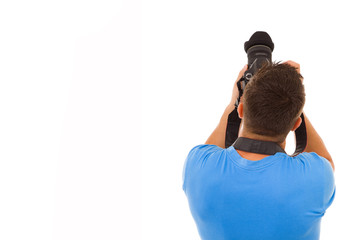 Young photographer with camera from the back, isolated on white