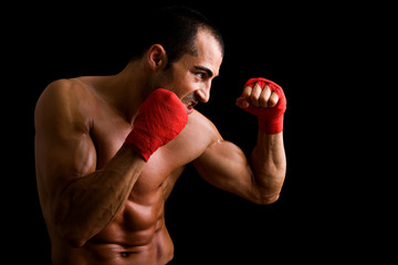 Fototapeta na wymiar Young Boxer fighter over black background