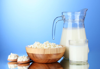 Tasty milk and cottage cheese on  blue background