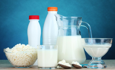 Dairy products on wooden table on blue background