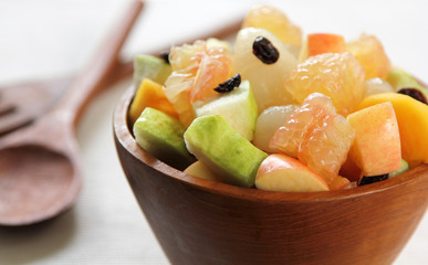 Healthy tropical fruits salad in a wood bowl