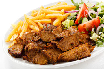 Grilled meat with French fries and vegetables