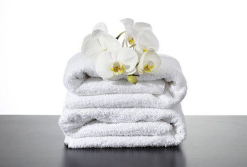 Fototapeta na wymiar Stosy ręczniki, orchidea, czarny i biały