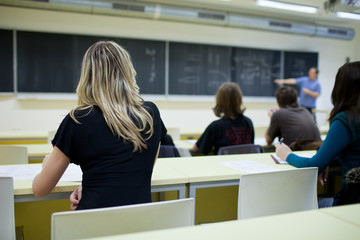 young, pretty female college student sitting in a classroom