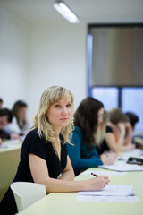 pretty female college student sitting in a classroom