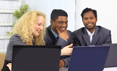 Fototapeta na wymiar Interracial business team working at laptop in a