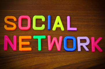 Social network in colorful toy letters on wood background