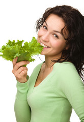 Beautiful young girl with green lettuce leaf