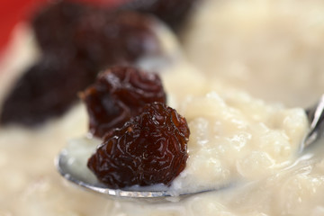 Rice pudding with raisins on spoon