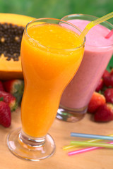 Papaya juice and strawberry milkshake with straws