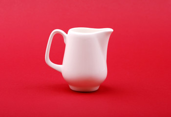 white milk jug on red