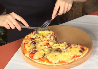 Wall murals Pizzeria Woman eating vegetarian pizza in a pizzeria