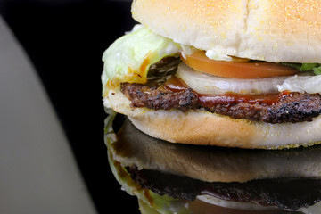 Hamburger with lettuce, tomato and onion isolated on black