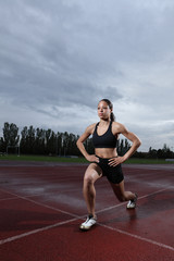 Obraz premium Lunge exercise for quadriceps by athlete on track