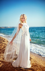 Fototapeta na wymiar Young and the beautiful bride on seacoast