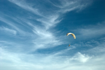 Flying paramotor in the blue sky