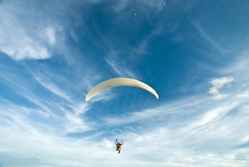 Flying paramotor in the blue sky