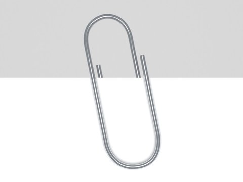 close up of a metal paper clip and paper