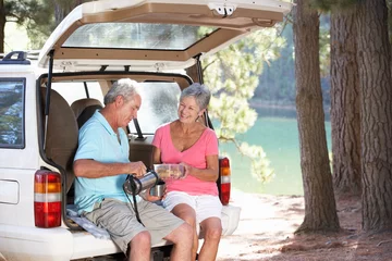Selbstklebende Fototapeten Älteres Paar beim Picknick auf dem Land © Monkey Business