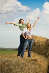 girls standing on hay